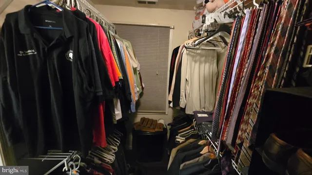 a view of walk in closet with clothes