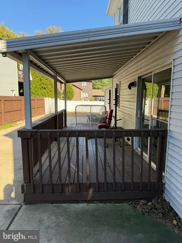 a view of backyard with large trees and a wooden fence