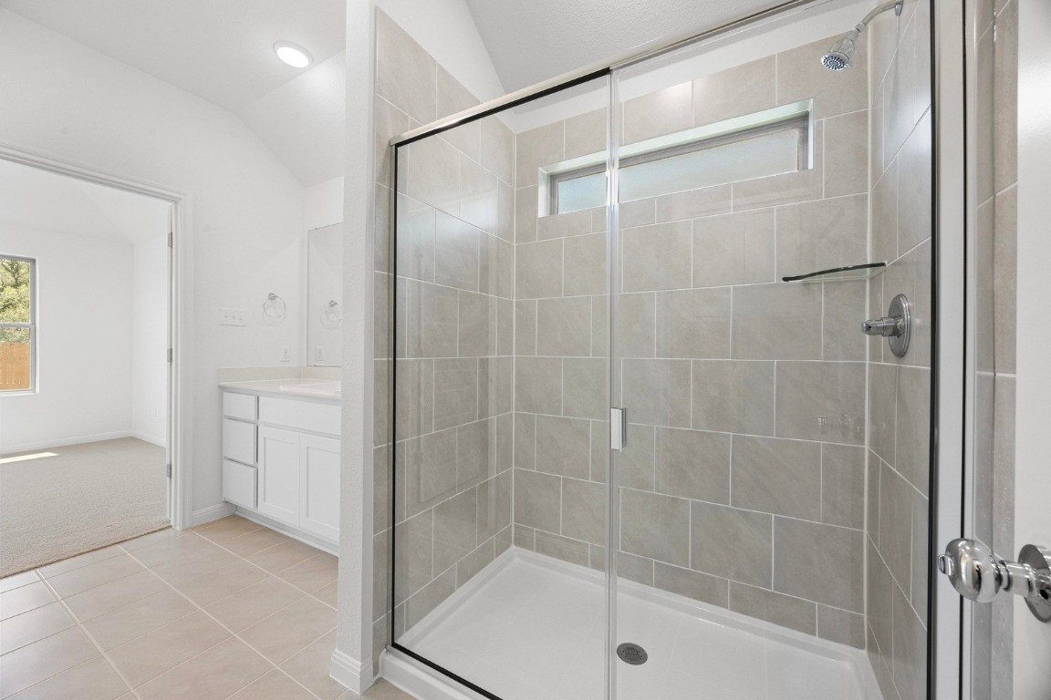298 Bendecido Loop Elgin, TX 78621 - Photo 26 of 40 a bathroom with a bathtub and a shower