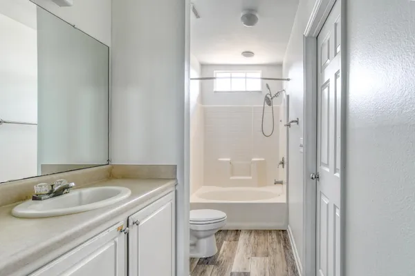 a bathroom with a granite countertop sink a toilet and shower