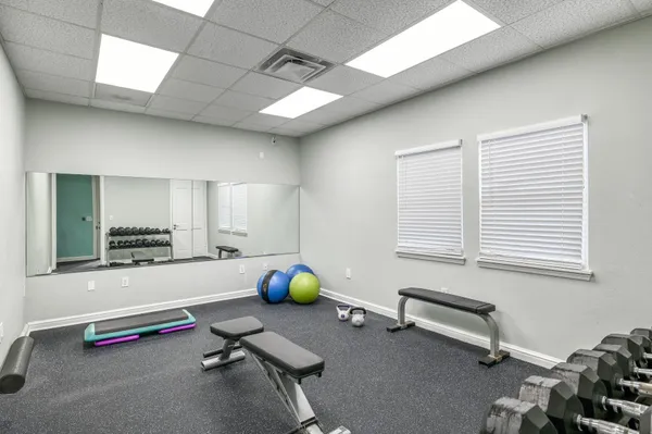 a room with gym equipment on the desk and window