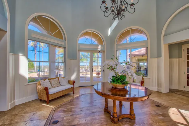 a living room with couches a table and a potted plant