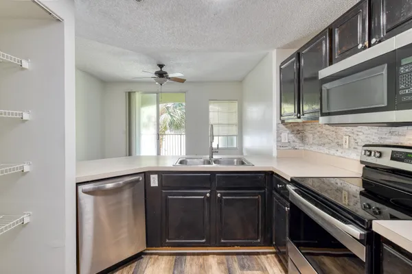 a kitchen with stainless steel appliances a sink stove and cabinets