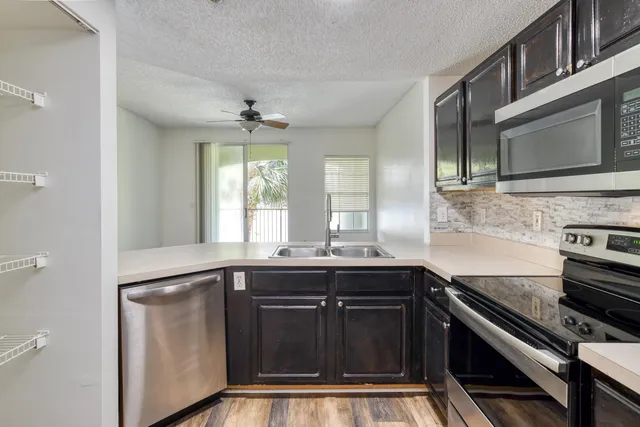 a kitchen with stainless steel appliances a sink stove and cabinets