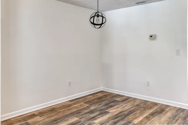 a view of a room with wooden floor and white walls