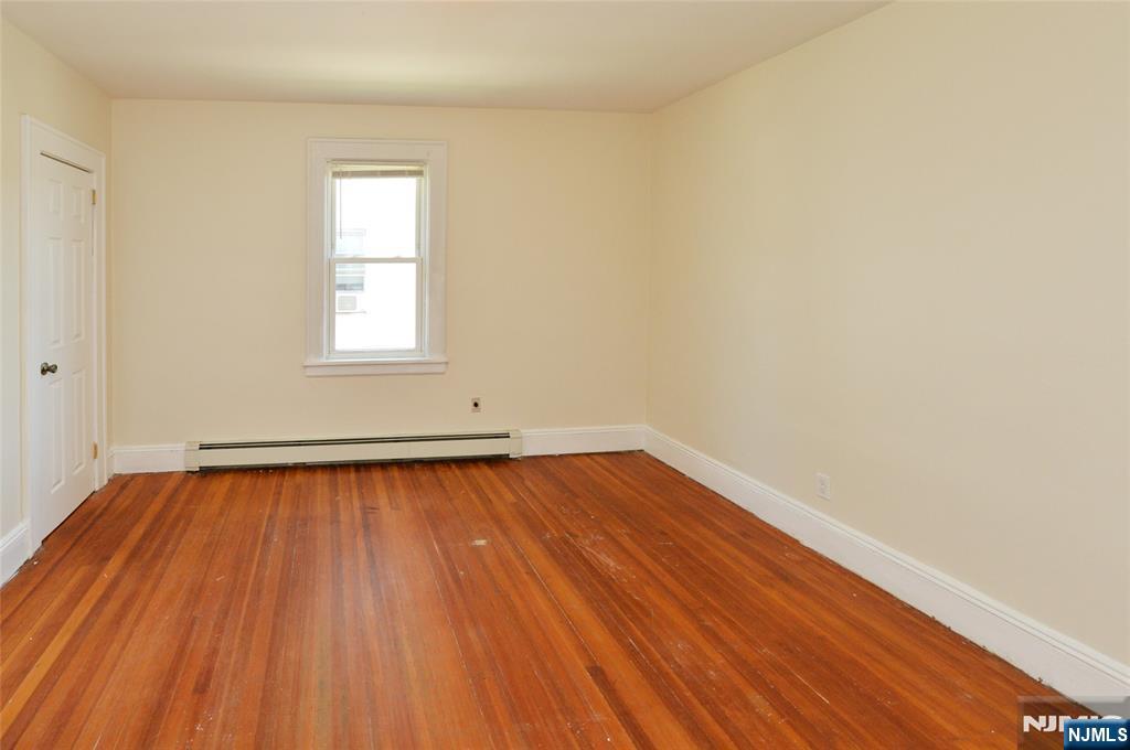 62 Broadway, Unit 1 Hackensack, NJ 07601 - Photo 10 of 25 an empty room with wooden floor and windows