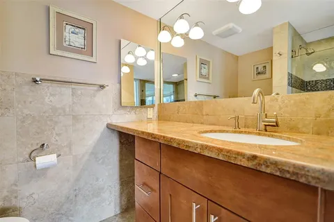 a bathroom with a granite countertop sink and a large mirror