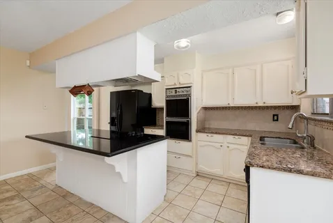 a kitchen with stainless steel appliances a stove a microwave and white cabinets