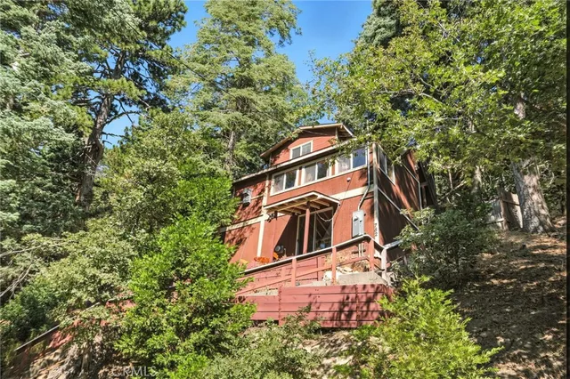 a front view of a house with a tree
