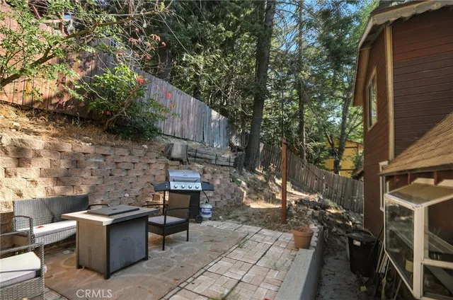 a view of a patio with table and chairs with wooden fence and plants