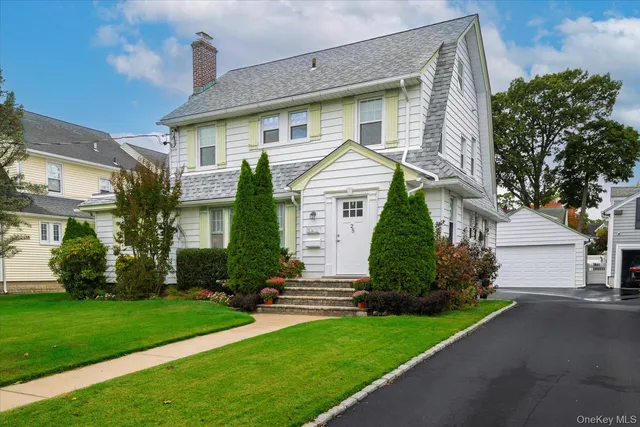a front view of a house with a garden and plants
