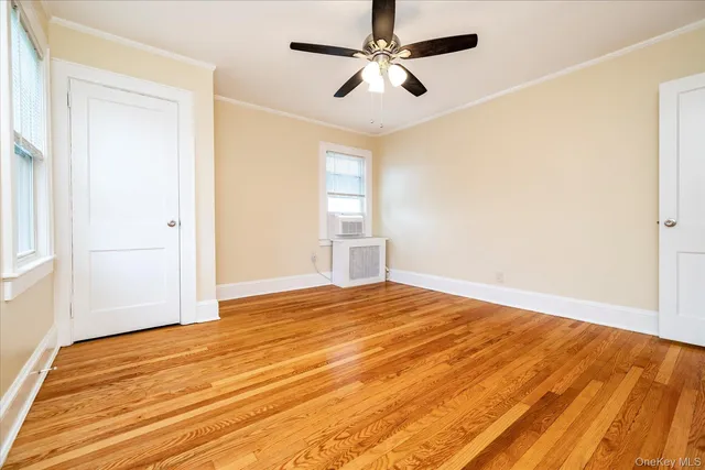 a view of empty room with wooden floor