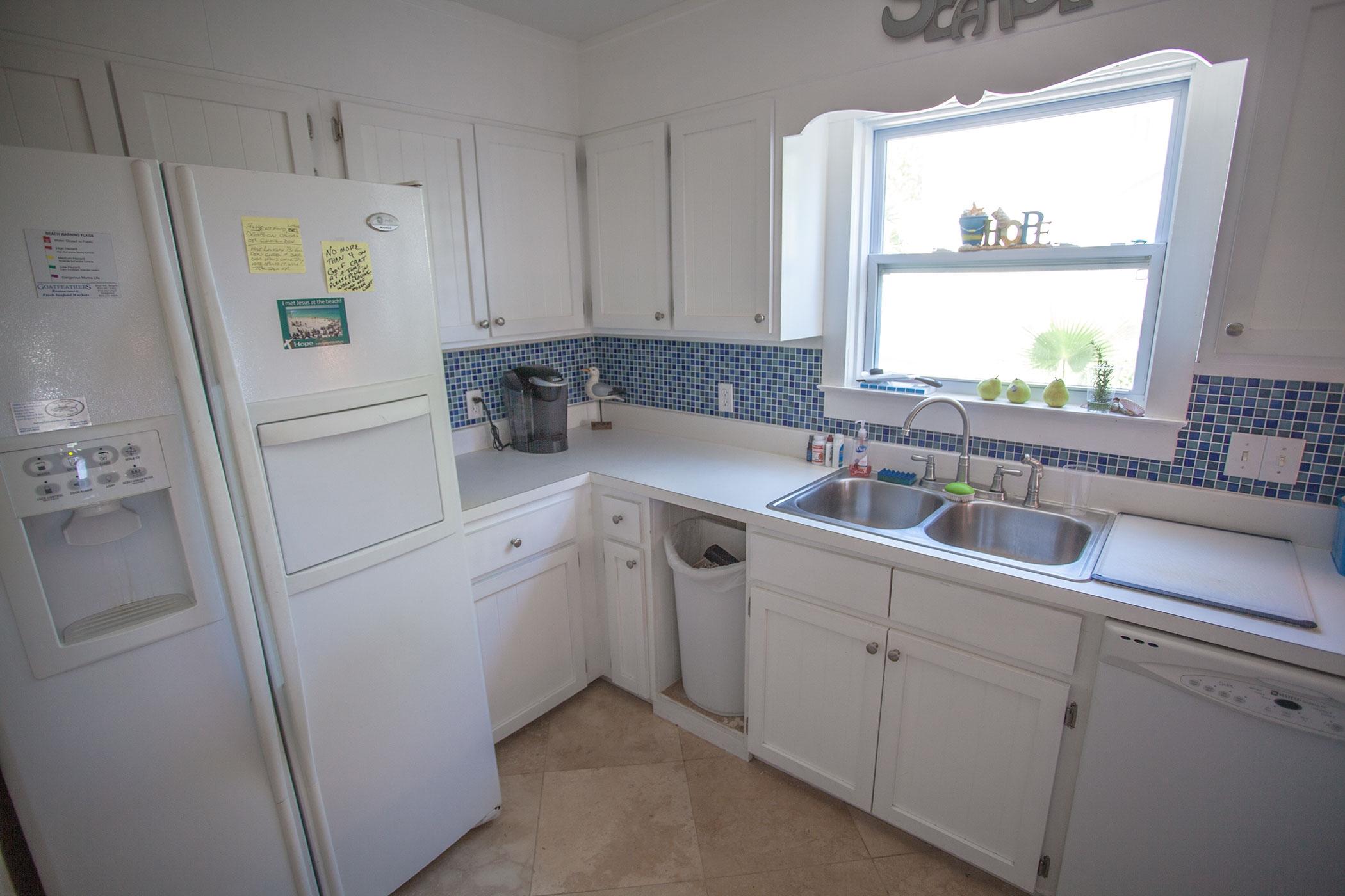 191 Blue Mountain Road, Unit 201 Santa Rosa Beach, FL 32459 - Photo 5 of 16 a kitchen with white cabinets and white appliances
