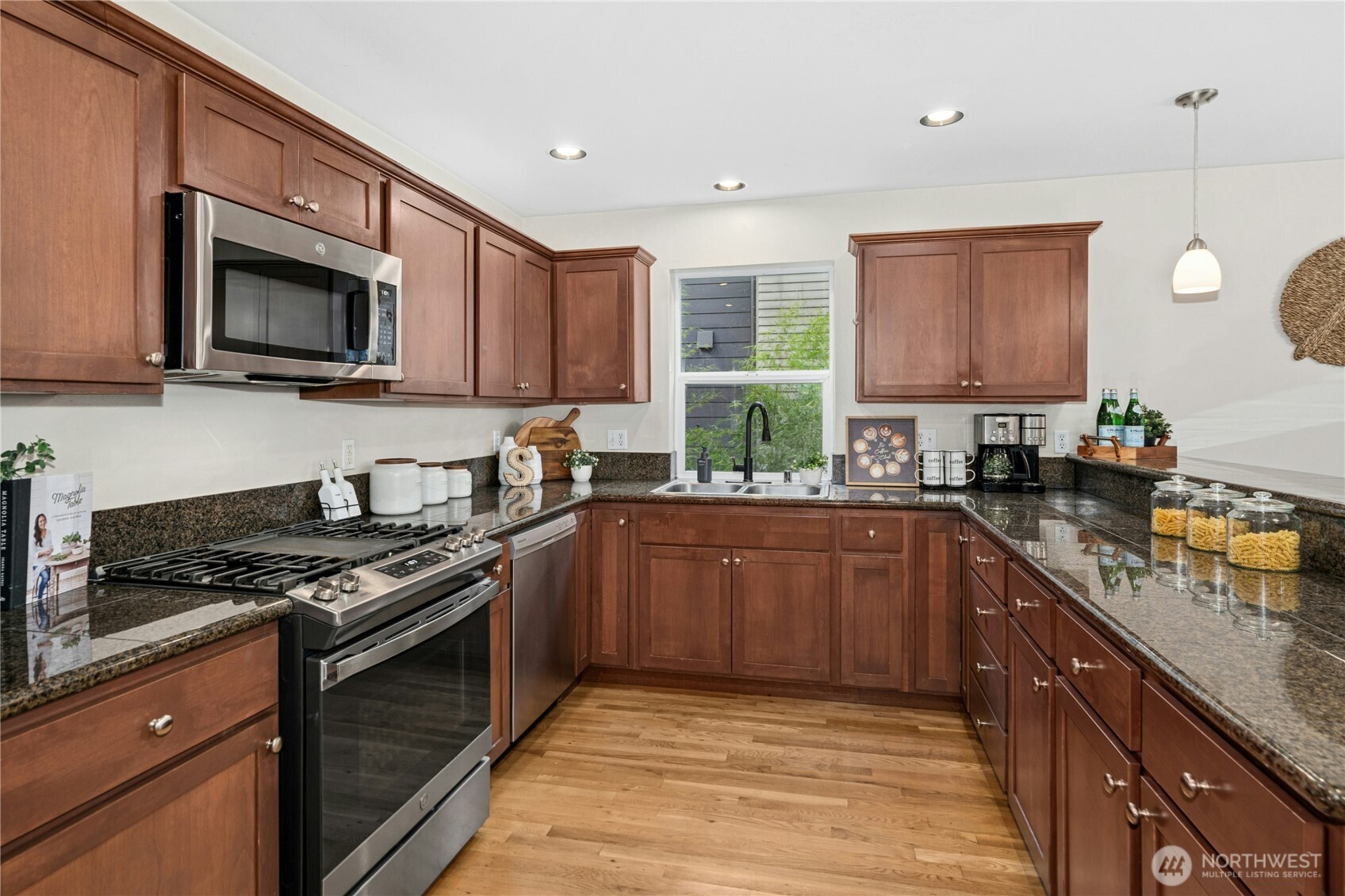 1341 14th Avenue South, Unit B Seattle, WA 98144 - Photo 11 of 26 a kitchen with stainless steel appliances granite countertop a stove sink microwave and window