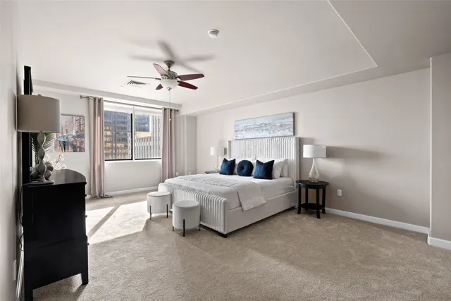 a spacious bedroom with a bed and a chandelier