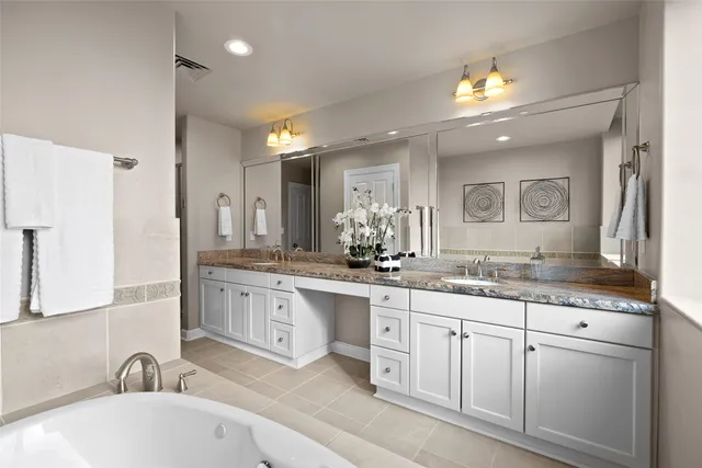 a bathroom with a granite countertop sink double and mirror