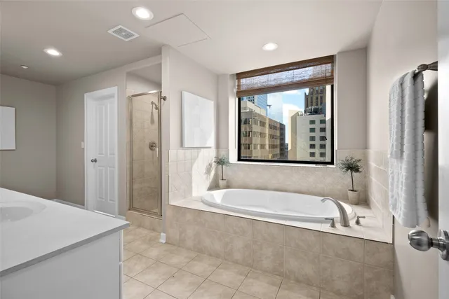 a spacious bathroom with a tub shower and sink