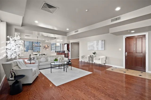 a living room with furniture a wooden floor and a chandelier