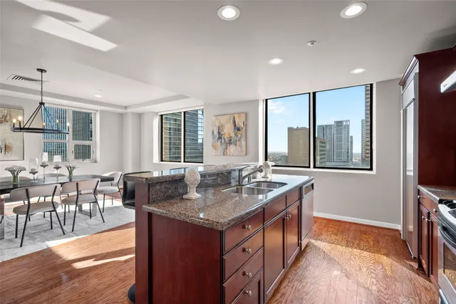 a dining hall with stainless steel appliances granite countertop sink stove and wooden floor