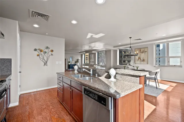 a kitchen with granite countertop cabinets a stove a dining table and chairs