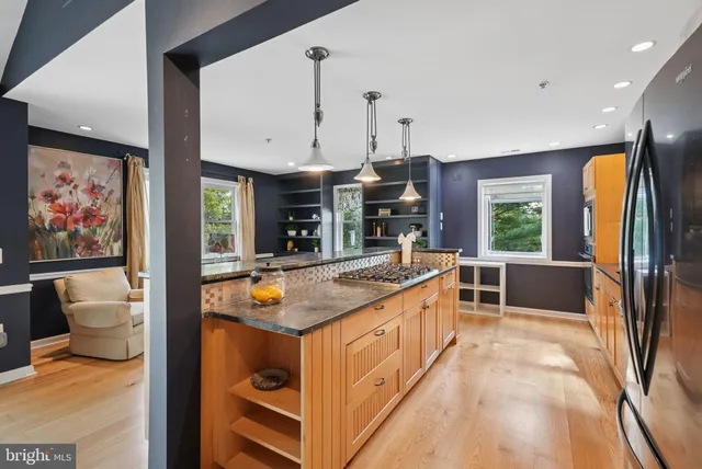 a kitchen with stainless steel appliances granite countertop a stove a sink and a refrigerator