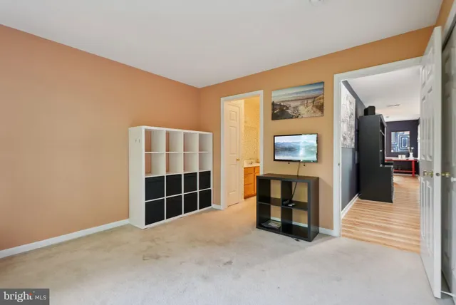 a view of an empty room with furniture and a window