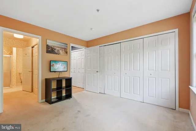 a view of an empty room with furniture and a window
