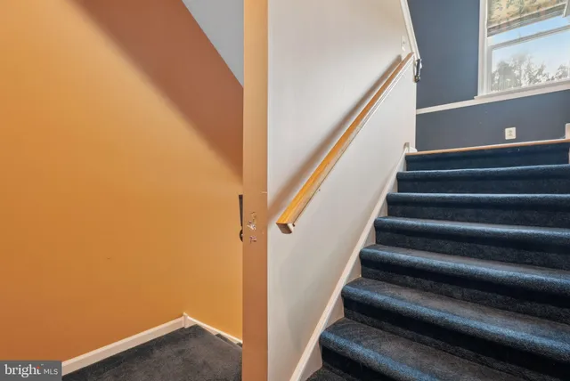 a view of staircase with wooden floor and white walls