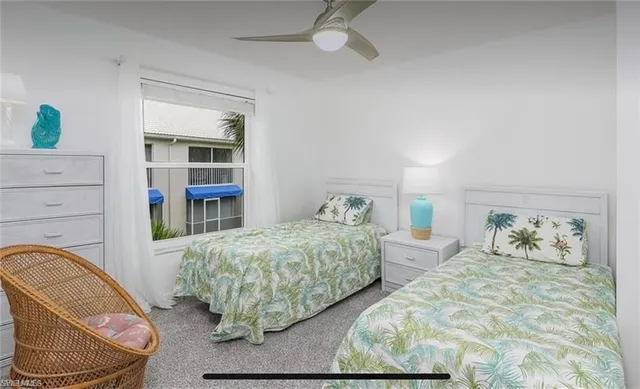 a bedroom with two beds and a book shelf