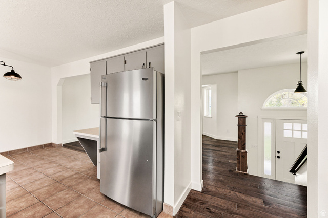 365 South Center Street Fielding, UT 84311 - Photo 10 of 41 Kitchen featuring freestanding refrigerator, hanging light fixtures, light countertops, a textured ceiling, and dark wood-type flooring