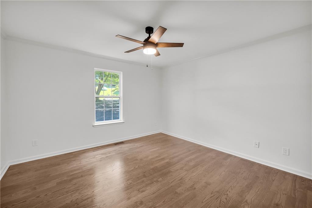 2941 Lake Hollow Road Gainesville, GA 30501 - Photo 32 of 53 an empty room with wooden floor fan and windows