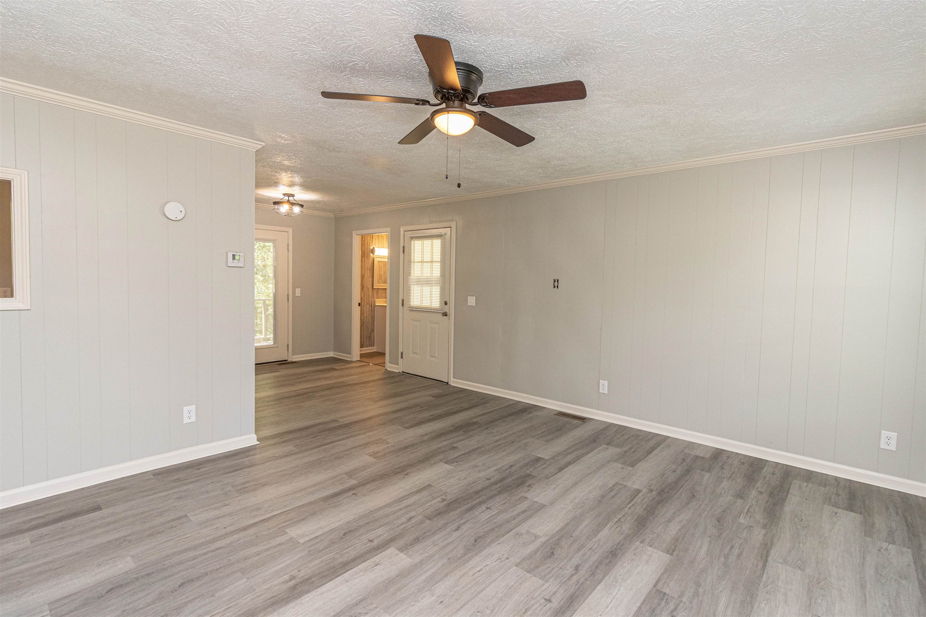 3532 Ramer Selmer Road Ramer, TN 38367 - Photo 7 of 15 an empty room with wooden floor and a ceiling fan