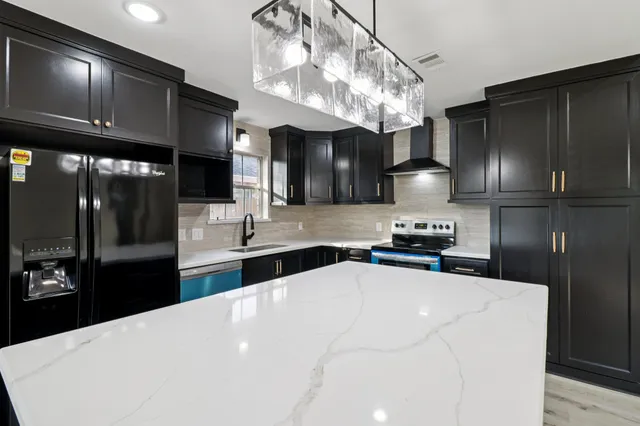 a kitchen with granite countertop a sink stainless steel appliances and cabinets