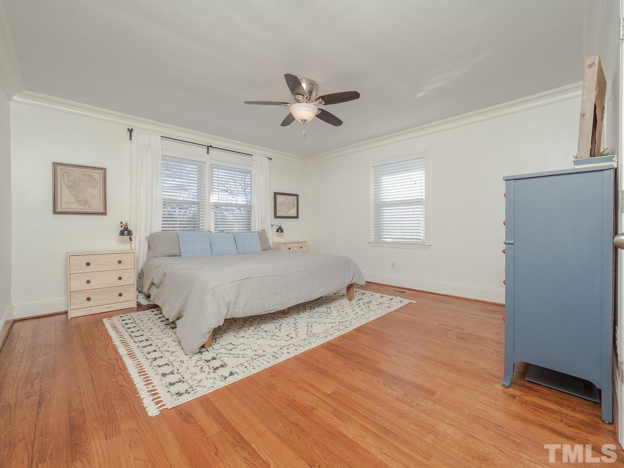 16 South Pettigrew Street Raleigh, NC 27610 - Photo 12 of 25 a bedroom with a bed and a dresser with wooden floor