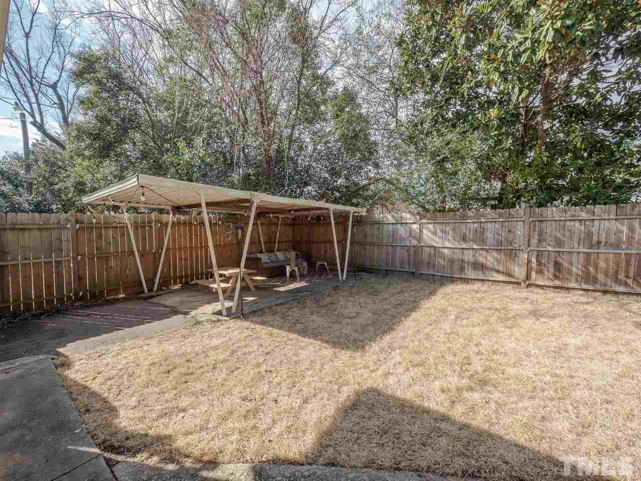 16 South Pettigrew Street Raleigh, NC 27610 - Photo 22 of 25 a view of a backyard with wooden fence and a large tree