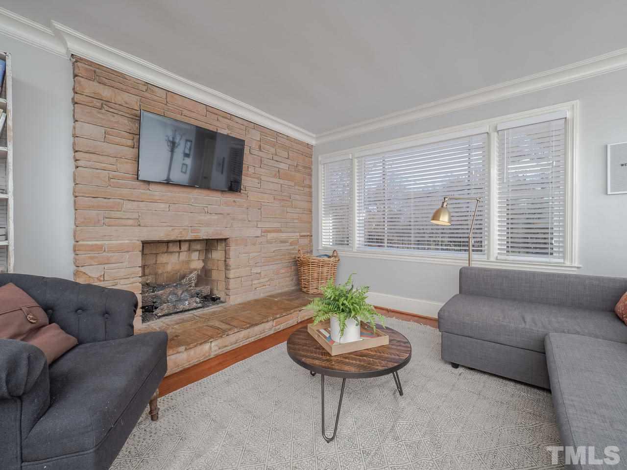 16 South Pettigrew Street Raleigh, NC 27610 - Photo 5 of 25 a living room with furniture a fireplace and windows