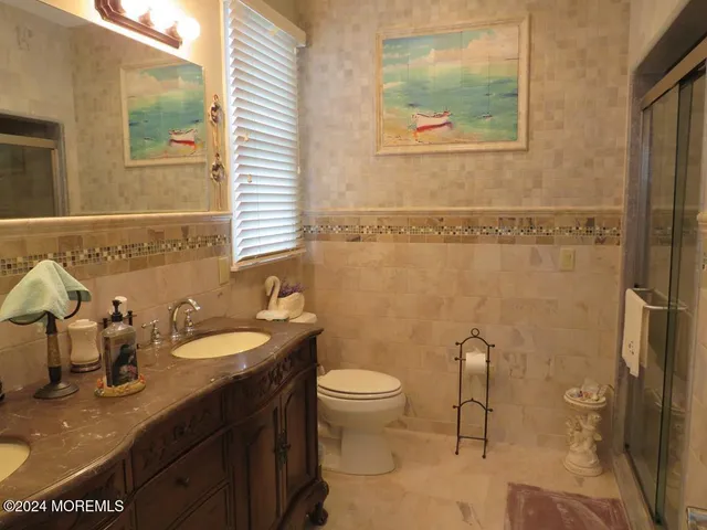 a bathroom with a granite countertop sink mirror vanity and toilet