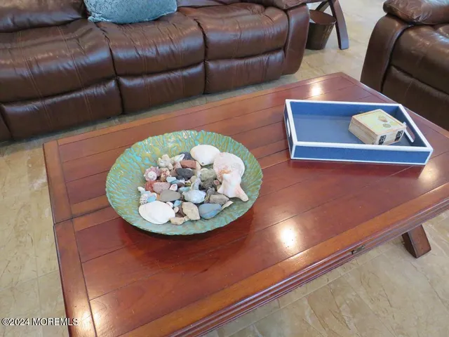 a living room with couches and a large mirror with wooden floor