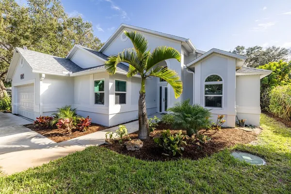 a front view of a house with a garden and a yard