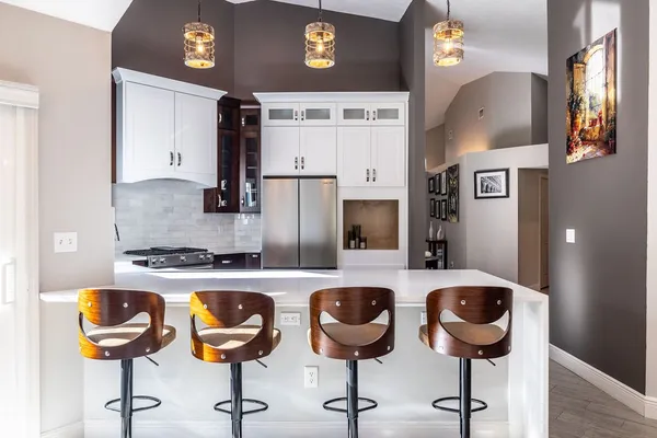a kitchen with cabinets and chairs