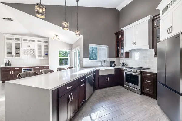 a kitchen with stainless steel appliances granite countertop a sink a stove and a refrigerator