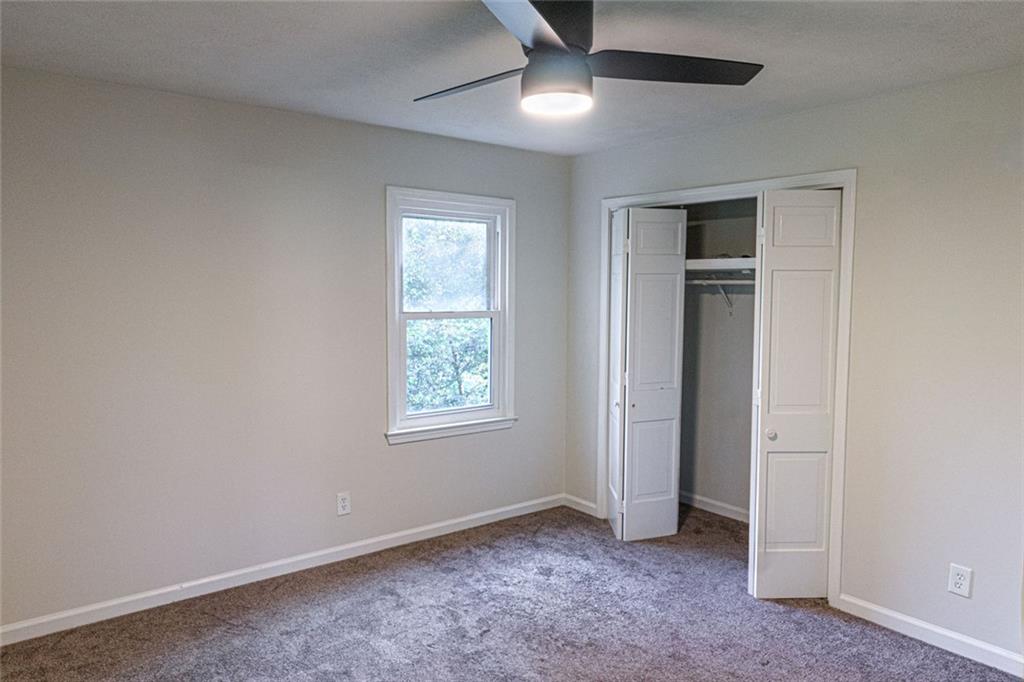 4970 Hull Road Southeast Conyers, GA 30094 - Photo 14 of 25 an empty room with windows and fan