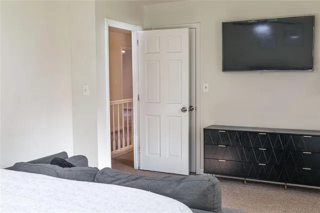 a living room with a bed and a flat screen tv