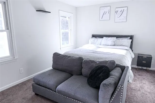 a bedroom with a bed couch and window