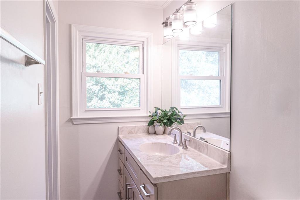 4970 Hull Road Southeast Conyers, GA 30094 - Photo 21 of 25 a bathroom with a granite countertop sink a mirror and a window