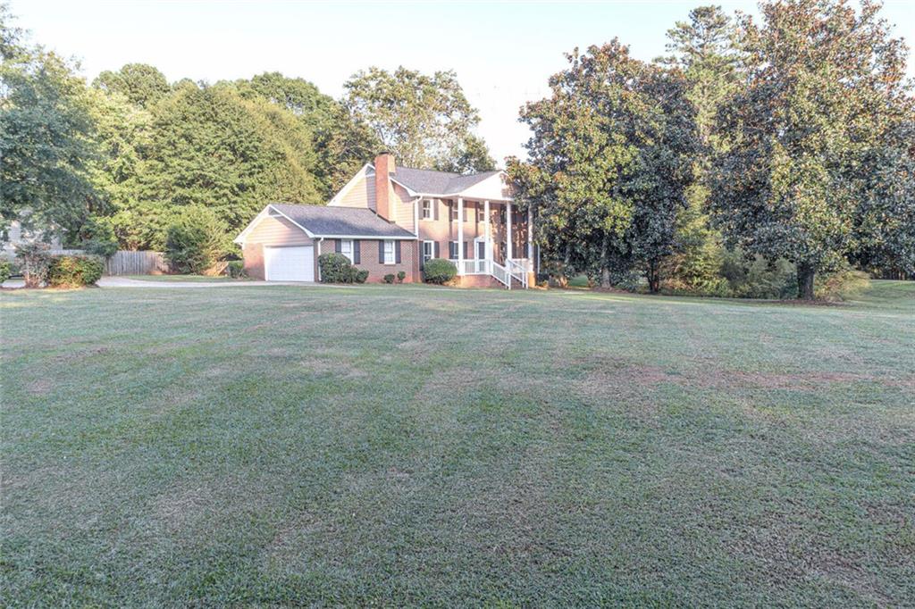 4970 Hull Road Southeast Conyers, GA 30094 - Photo 25 of 25 a view of a big house with a big yard and large trees