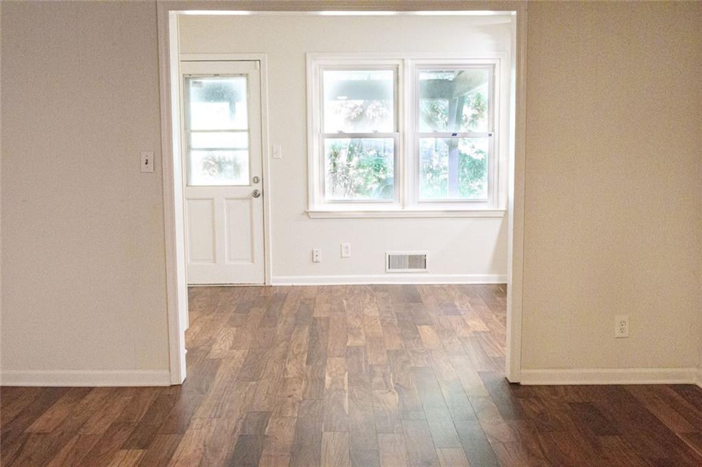 4970 Hull Road Southeast Conyers, GA 30094 - Photo 4 of 25 an empty room with wooden floor and windows