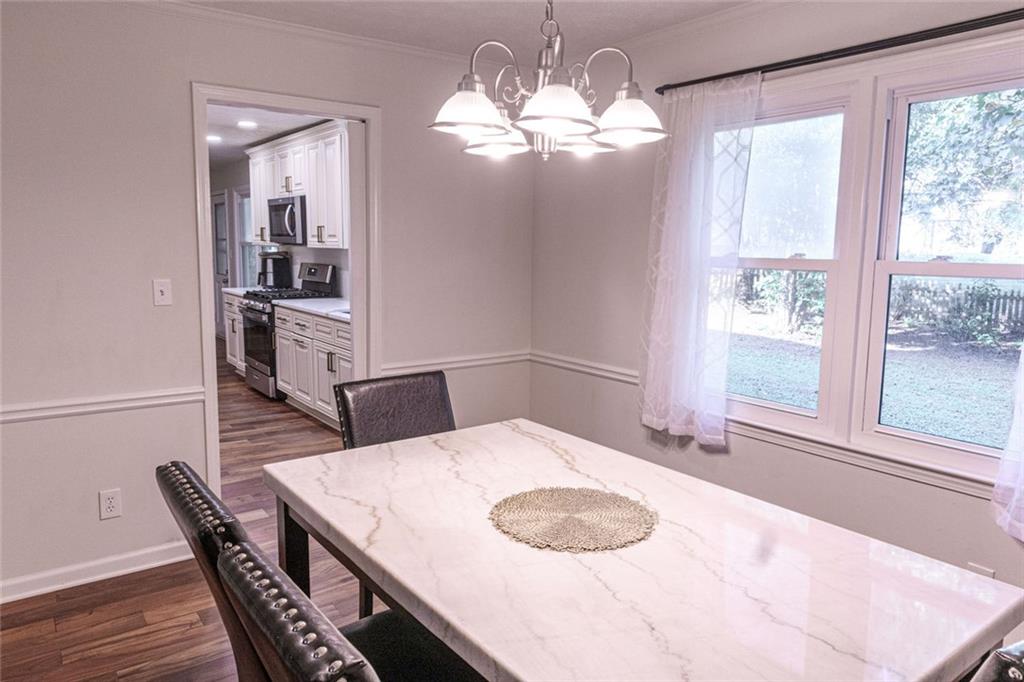 4970 Hull Road Southeast Conyers, GA 30094 - Photo 6 of 25 a view of a dining room with furniture and wooden floor