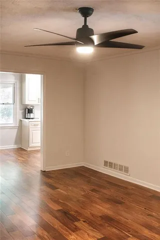 a view of empty room with wooden floor