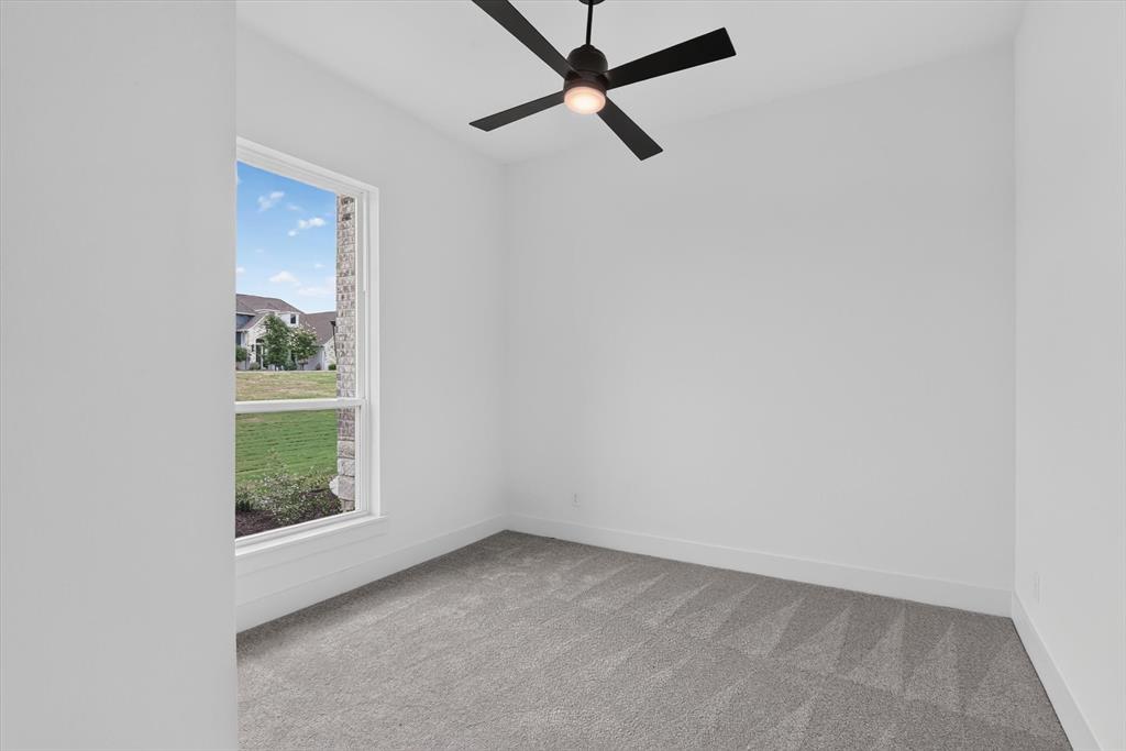 471 Red Bird Drive Springtown, TX 76082 - Photo 23 of 35 Room featuring a single-pane window, neutral carpet flooring, white walls, and a ceiling fan with integrated lighting